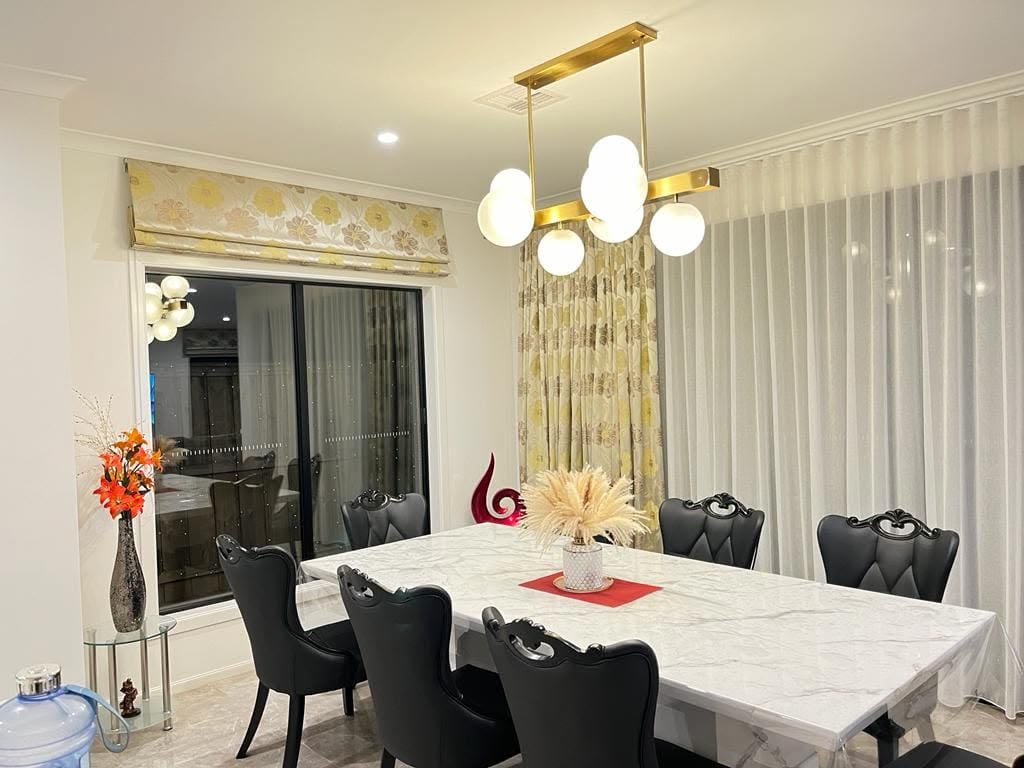 Floral roman blind and sheers in a dining room