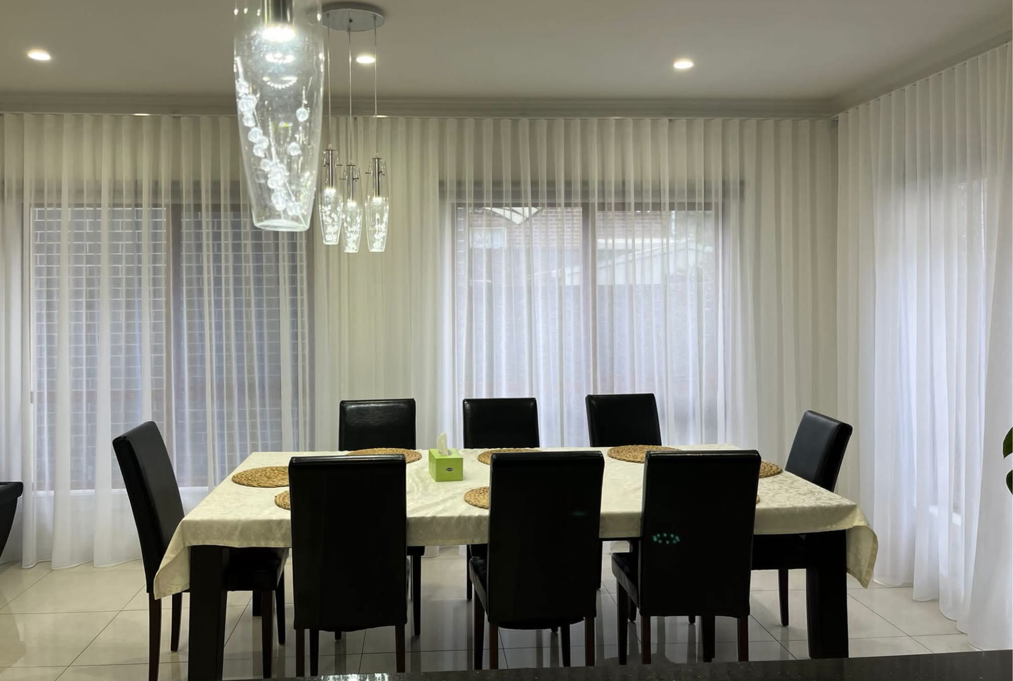 White sheer curtains around a formal dining setting