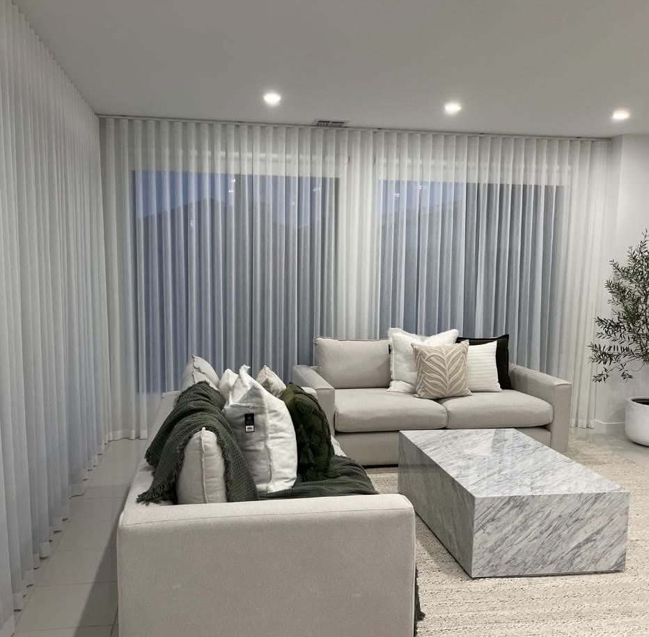 Sheer curtains in a lounge with a marble coffee table