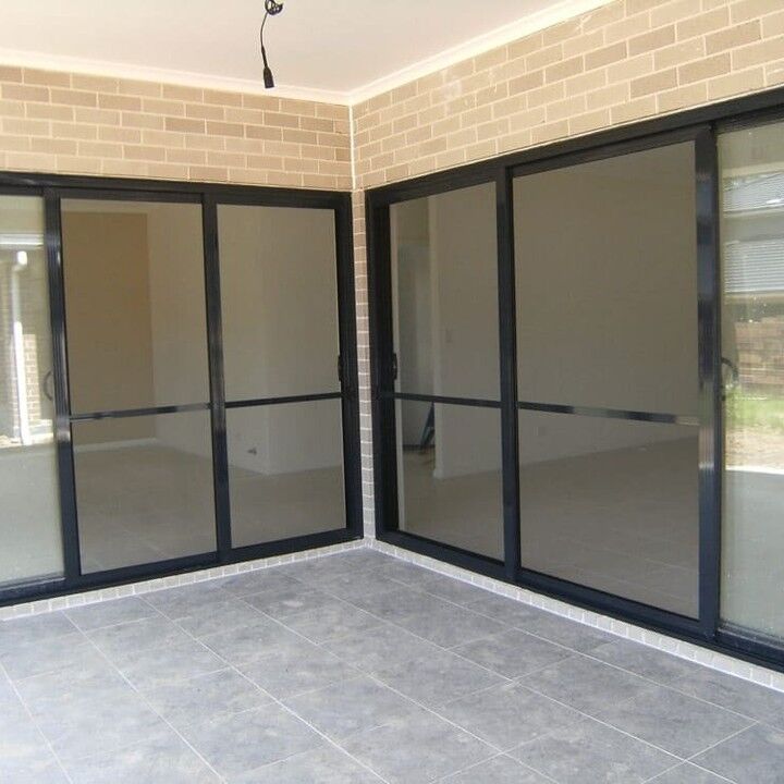 Black-framed fly screen sliding doors on a corner alfresco
