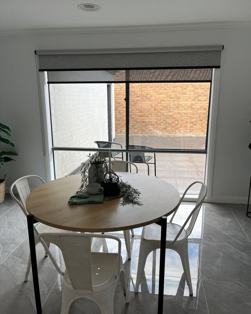 Roller blind on a sliding door beside a dining table