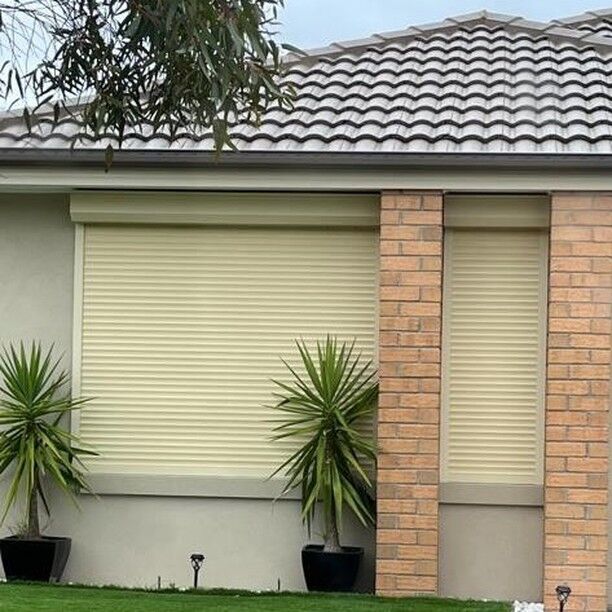 Cream roller shutters on a brick home