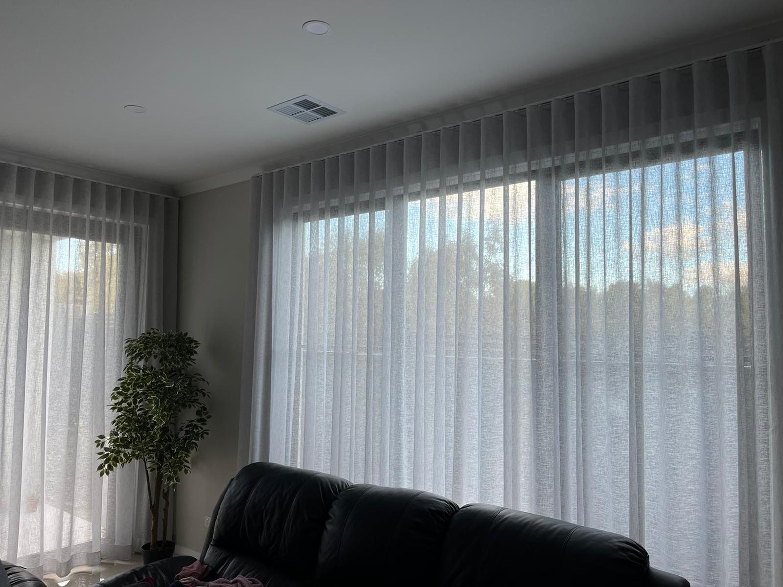 S-fold sheer curtains across open-plan living windows